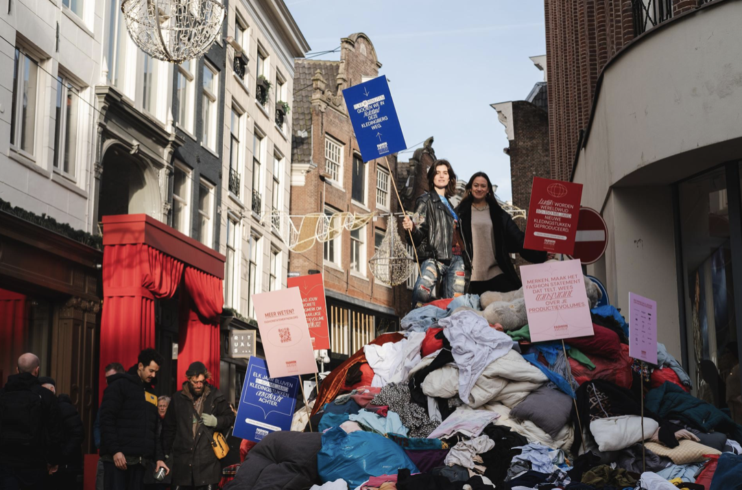 Modeprotest in Kalverstraat: enorme berg afgedankte kleding vraagt aandacht voor verspilling